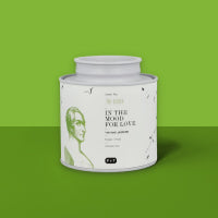 Weißes 250g Teeglas mit grünem Design und Aufschrift 100 % natürlich vor grünem Hintergrund
