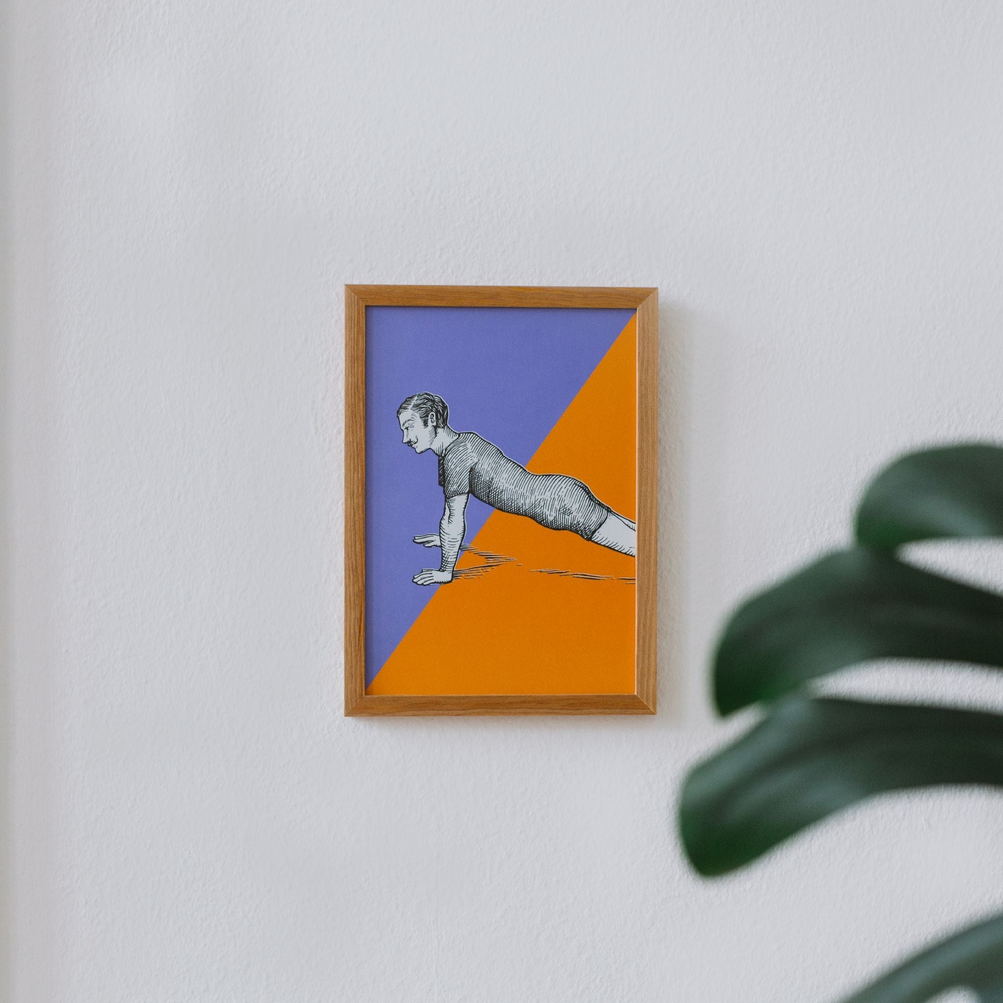 Modernes, minimalistisches Interieur mit gerahmtem Kunstwerk einer stilisierten Person in Plank-Position neben grünen Pflanzen.