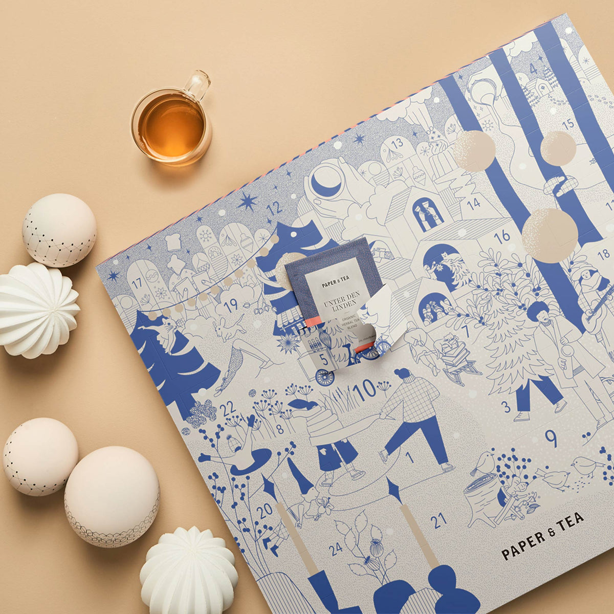 Adventskalender mit blauen Illustrationen, Türchen zeigt Kräutertee von PAPER & TEA, Teetasse und Dekokugeln