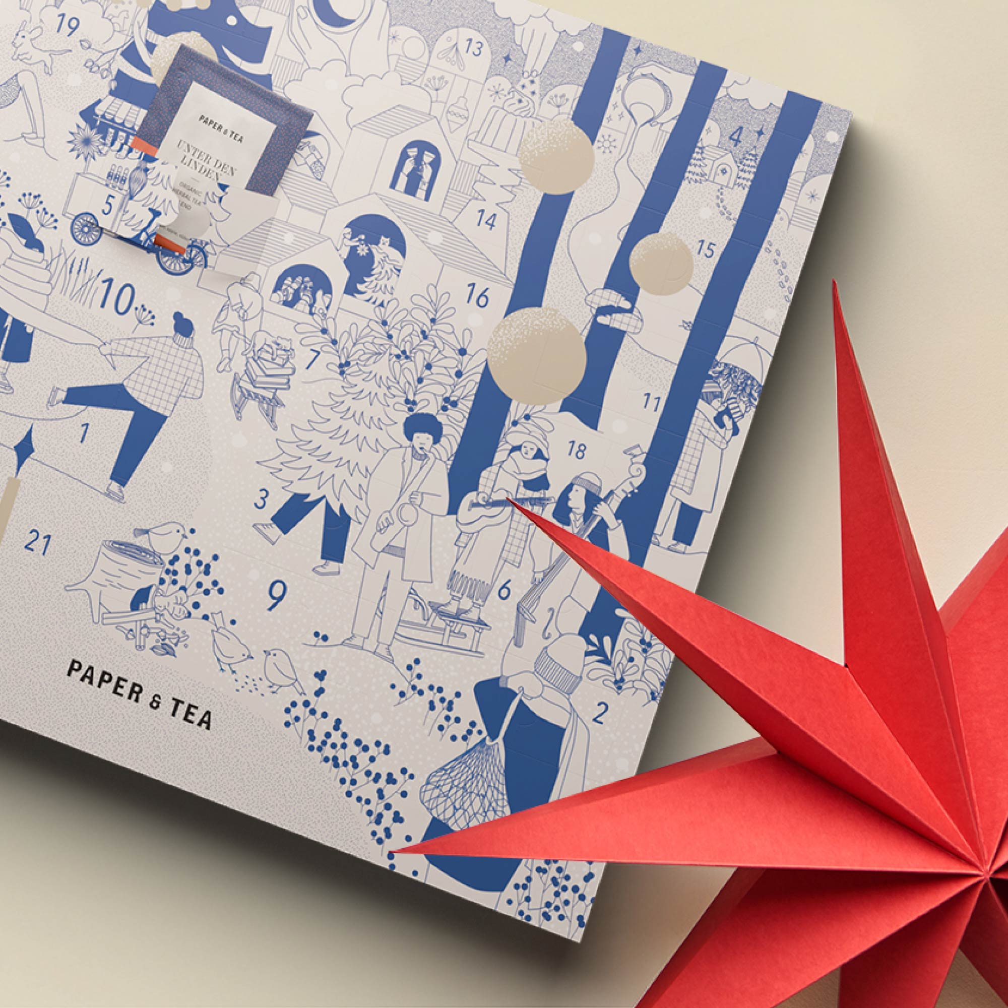 Blau-weißer Adventskalender mit festlichen Motiven und rotem Origami-Stern, Tee "Unter den Linden".