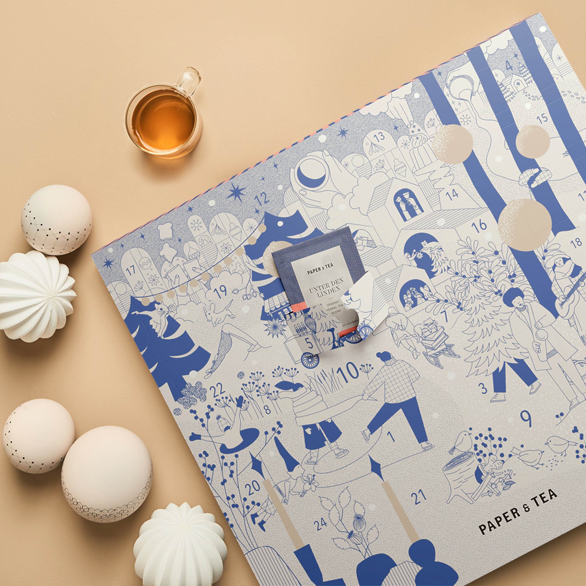 Adventskalender mit blauen Illustrationen, Türchen zeigt Kräutertee von PAPER & TEA, Teetasse und Dekokugeln